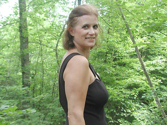 Frau im schwarzen Kleid im Wald
